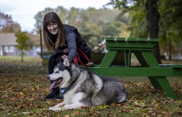 Person petting dog outside